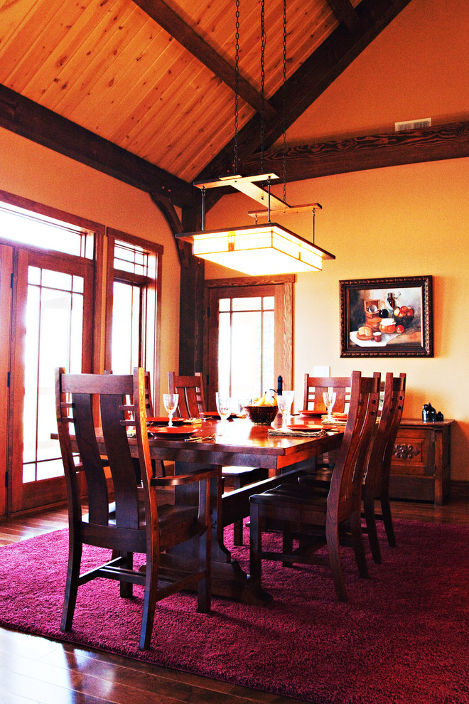 Example of a mid-sized mountain style medium tone wood floor and brown floor dining room design with beige walls and no fireplace