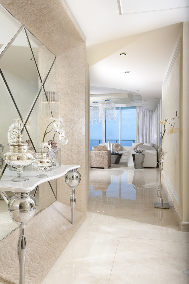 This is an example of a mid-sized contemporary foyer in Miami with beige walls, marble floors and white floor.