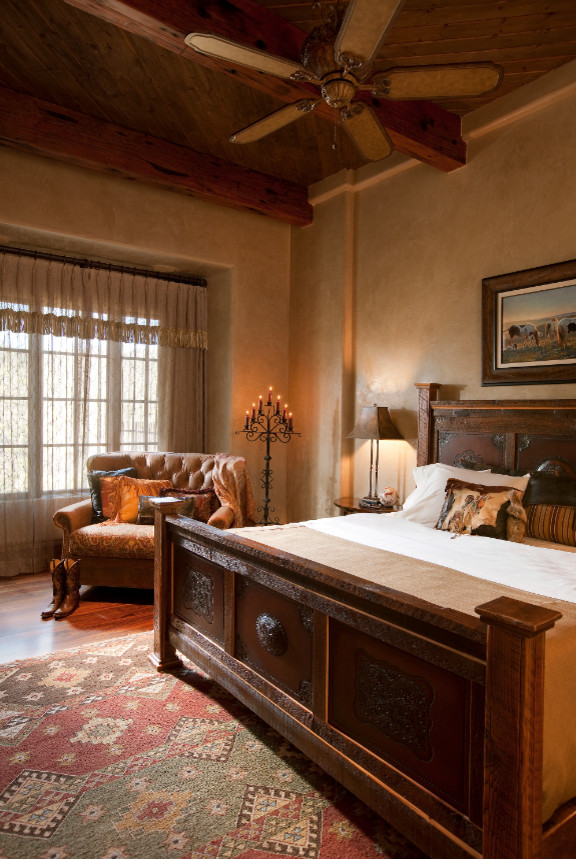 Inspiration for a large country guest bedroom in Phoenix with beige walls, medium hardwood floors, a standard fireplace and a stone fireplace surround.