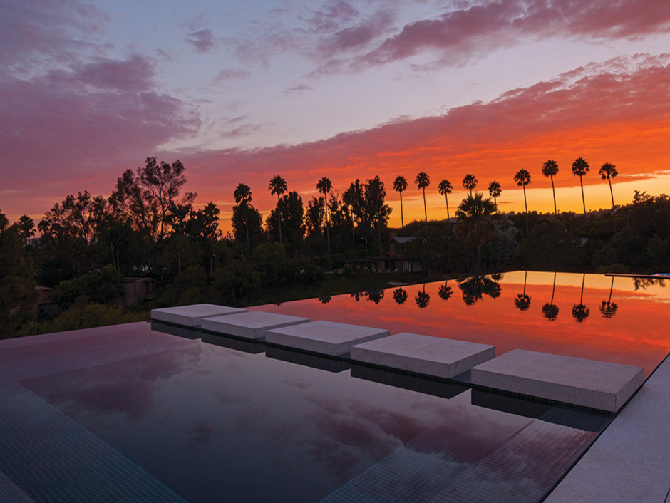 This is an example of a mid-sized contemporary backyard rectangular infinity pool in Los Angeles with concrete slab.