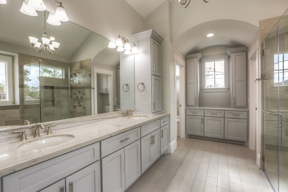 Example of a mid-sized transitional white tile and ceramic tile ceramic tile and gray floor drop-in bathtub design in Orlando with shaker cabinets, white cabinets, a two-piece toilet, white walls, an undermount sink, granite countertops and a hinged shower door