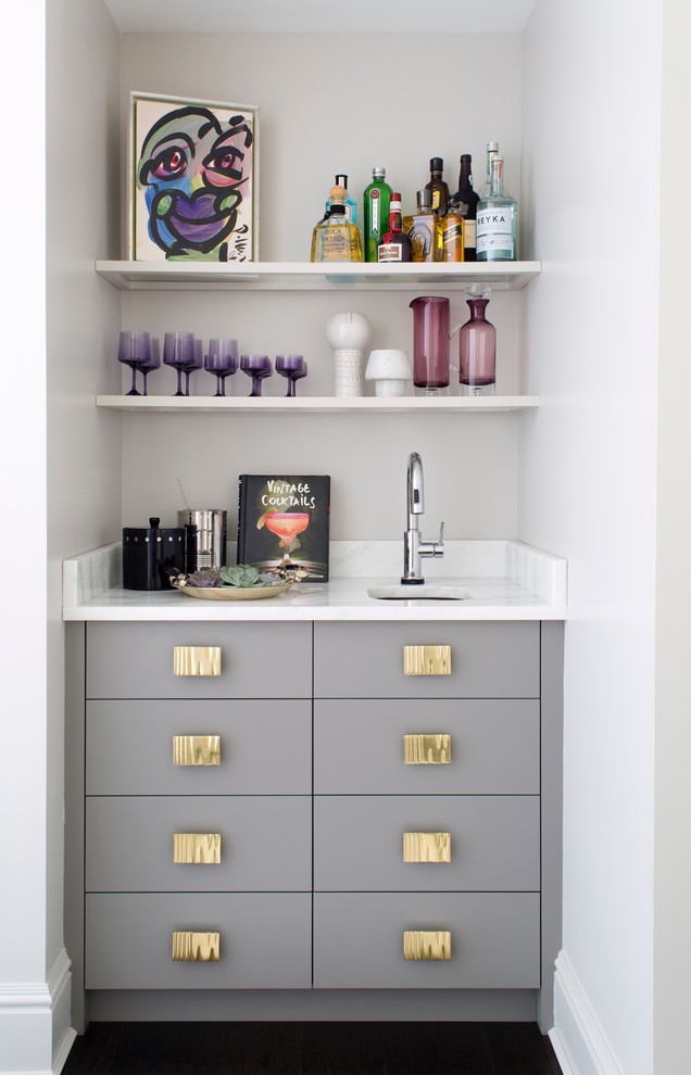 Inspiration for a mid-sized modern single-wall wet bar in New York with flat-panel cabinets, grey cabinets, quartzite benchtops, an undermount sink, dark hardwood floors, brown floor and white benchtop.