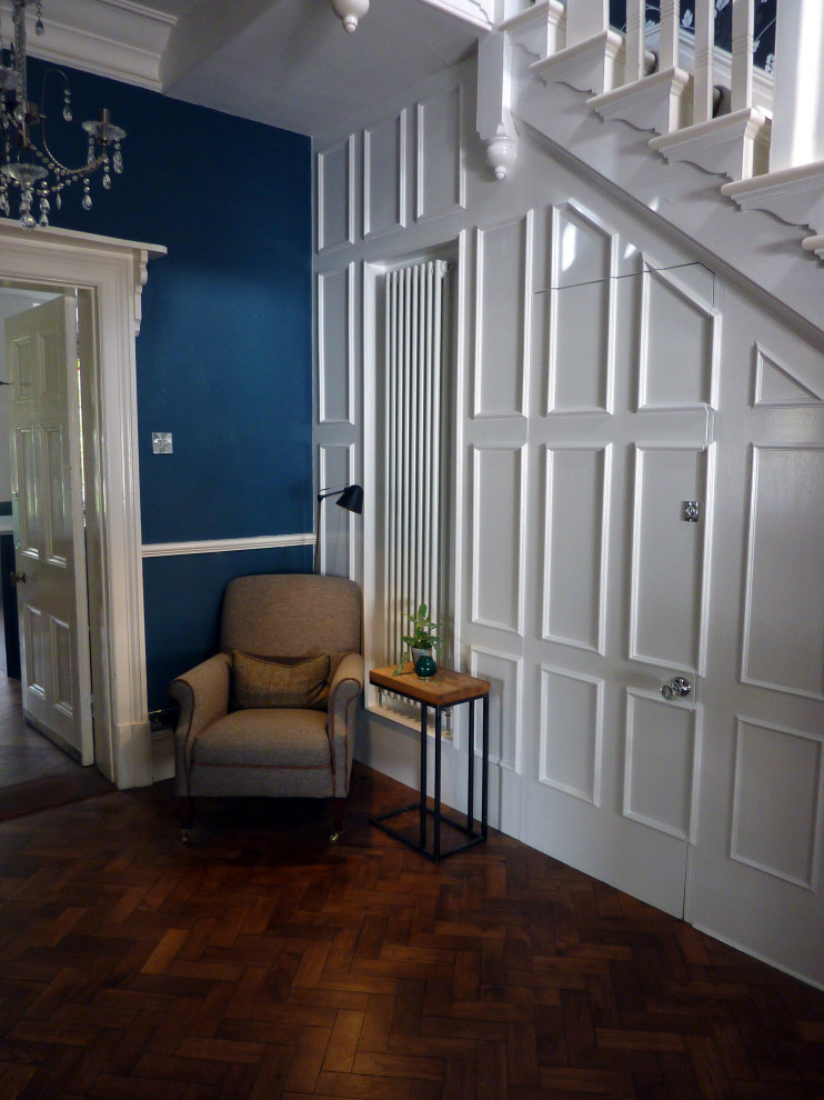 Design ideas for a small transitional hallway in West Midlands with white walls, dark hardwood floors and panelled walls.