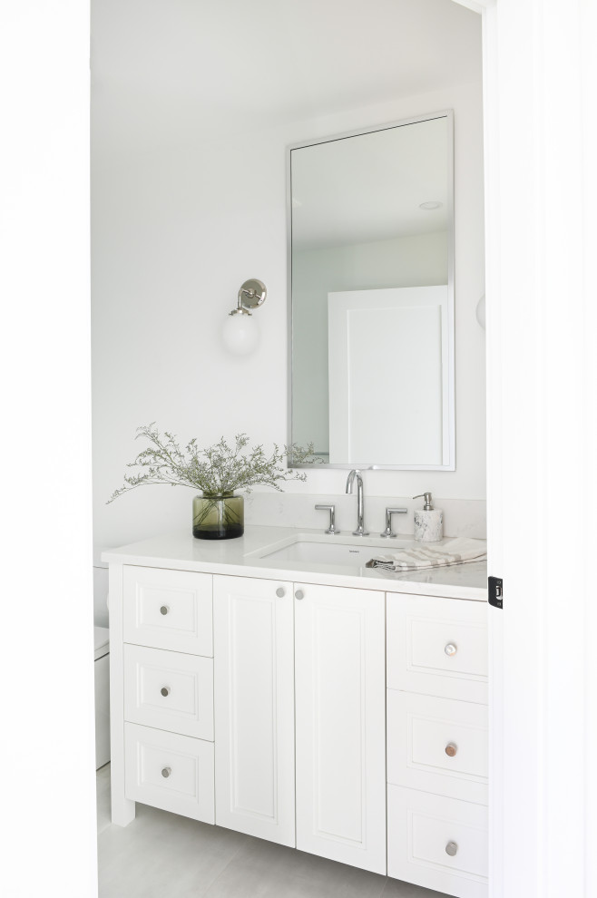 Medium sized traditional bathroom in Vancouver with shaker cabinets, white cabinets, a two-piece toilet, white tiles, white walls, porcelain flooring, a submerged sink, engineered stone worktops, beige floors, white worktops, a wall niche, a single sink and a freestanding vanity unit.
