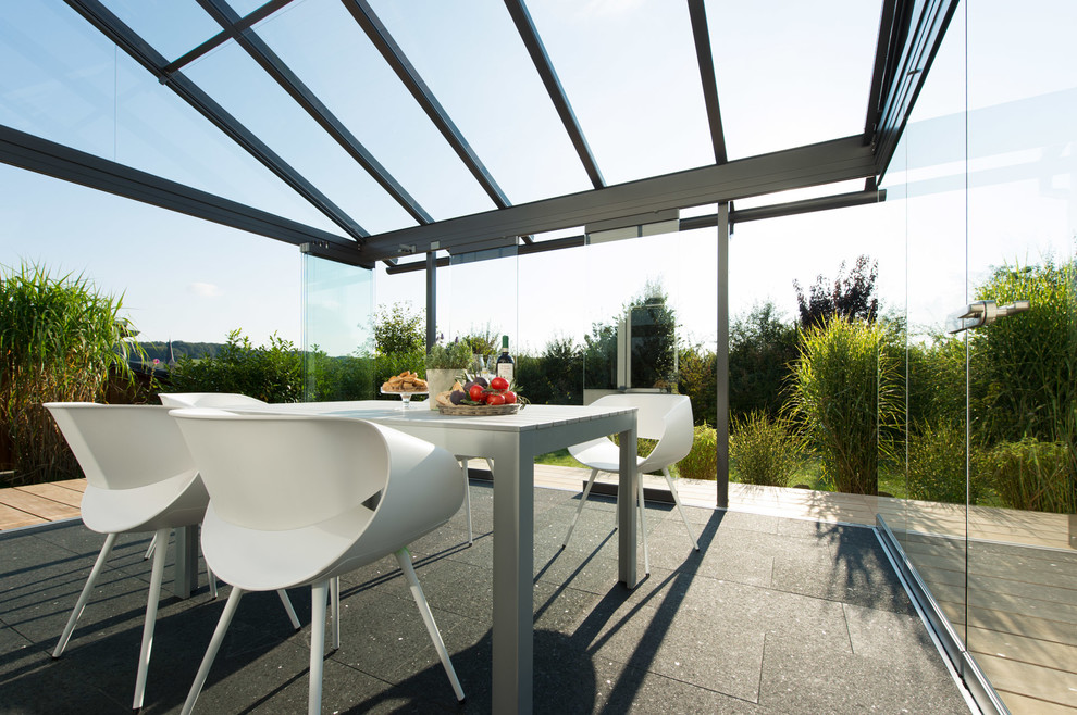 Photo of a mid-sized contemporary sunroom in Bremen with a glass ceiling.