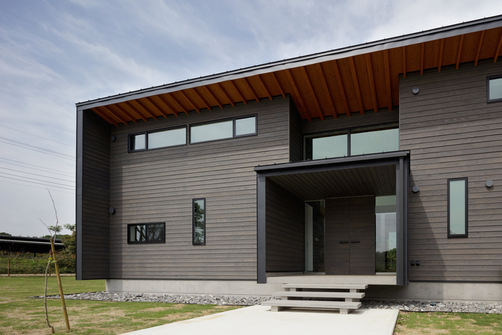 Mid-sized modern one-storey grey house exterior in Other with a shed roof and a metal roof.