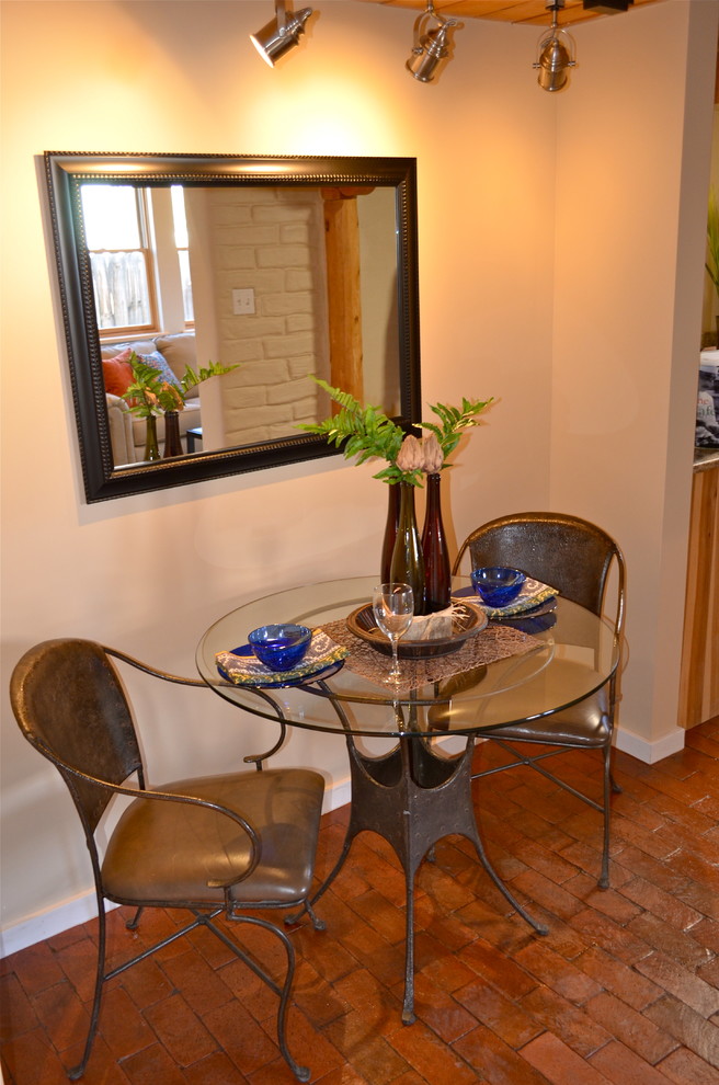 Photo of a mid-sized dining room in Albuquerque with white walls and brick floors.