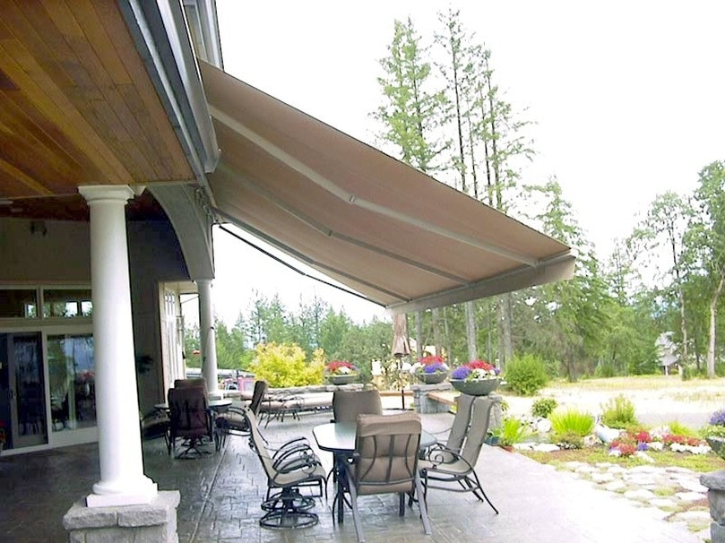 Inspiration for a mid-sized traditional backyard patio in Portland with concrete pavers and an awning.