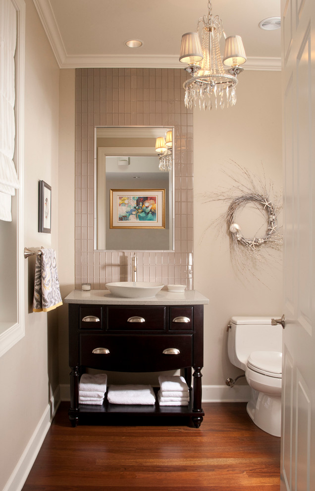 This is an example of a large traditional bathroom in Seattle with a vessel sink, dark wood cabinets, a one-piece toilet, beige tile, glass tile, beige walls, dark hardwood floors and flat-panel cabinets.