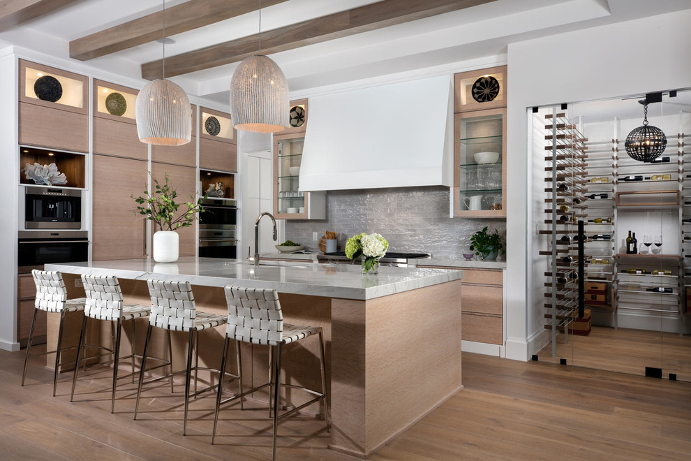 Design ideas for a transitional l-shaped kitchen in Miami with an undermount sink, flat-panel cabinets, light wood cabinets, grey splashback, stainless steel appliances, with island, grey benchtop, medium hardwood floors and brown floor.