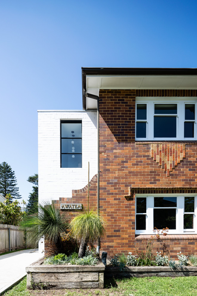 Diseño de fachada de casa blanca minimalista de tamaño medio de dos plantas con revestimiento de ladrillo