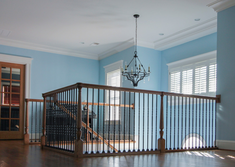 This is an example of an expansive traditional wood spiral staircase in DC Metro with wood risers and metal railing.