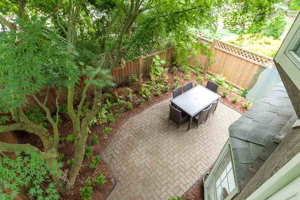 Photo of a mid-sized contemporary backyard patio in Vancouver with brick pavers and no cover.