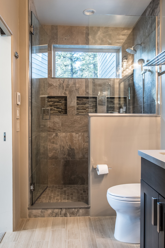 Mid-sized mountain style 3/4 porcelain tile and beige floor alcove shower photo in Phoenix with shaker cabinets, dark wood cabinets, beige walls, an undermount sink, solid surface countertops, a hinged shower door and beige countertops