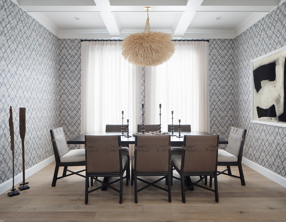 This is an example of a transitional separate dining room in San Francisco with multi-coloured walls, coffered, wallpaper and light hardwood floors.