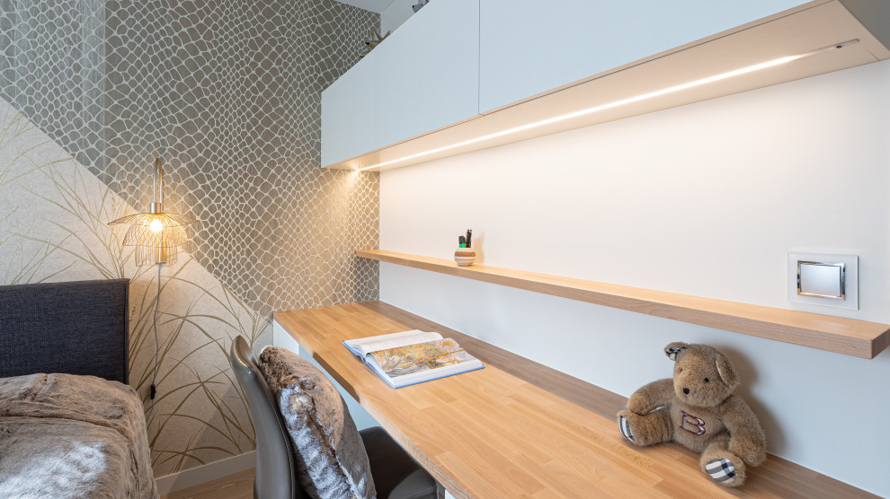 Großes Modernes Arbeitszimmer ohne Kamin mit grauer Wandfarbe, hellem Holzboden, Einbau-Schreibtisch, beigem Boden und Tapetenwänden in Grenoble