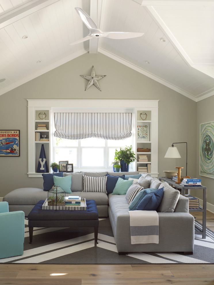 Photo of a large beach style family room in San Diego with grey walls and light hardwood floors.