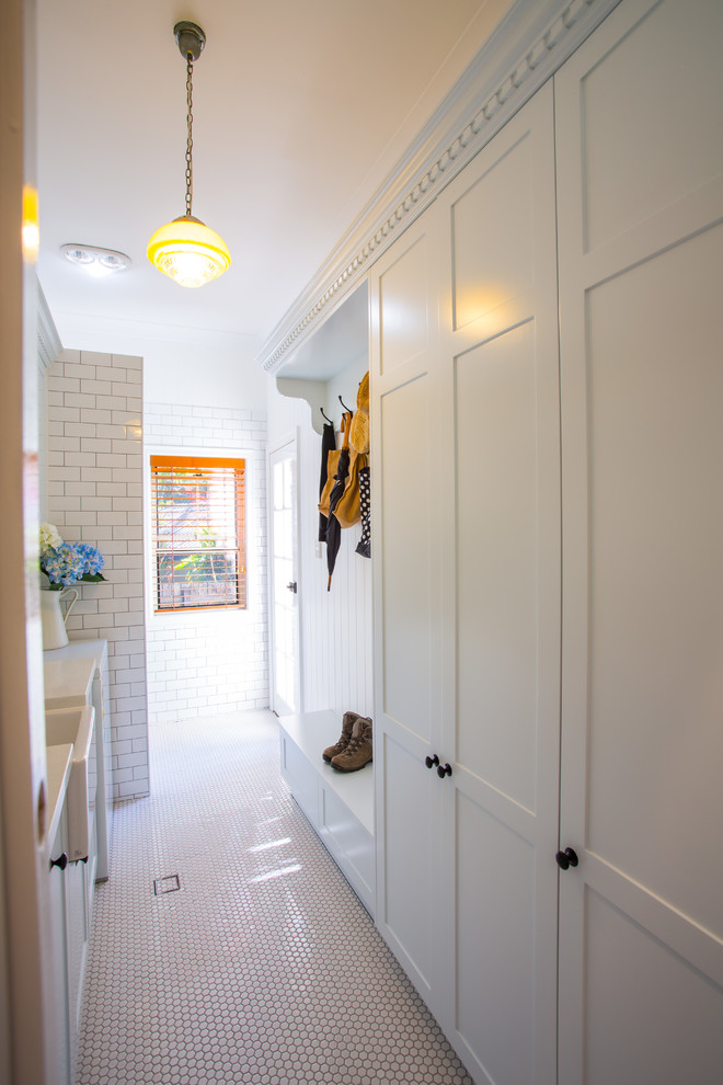Photo of a large traditional laundry room in Brisbane with a farmhouse sink, shaker cabinets, white cabinets, quartz benchtops, white walls and ceramic floors.