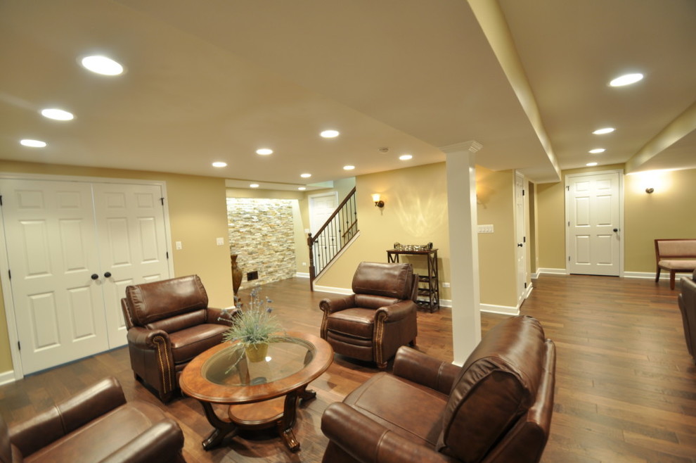 Photo of a large contemporary fully buried basement in Chicago with yellow walls, dark hardwood floors and no fireplace.
