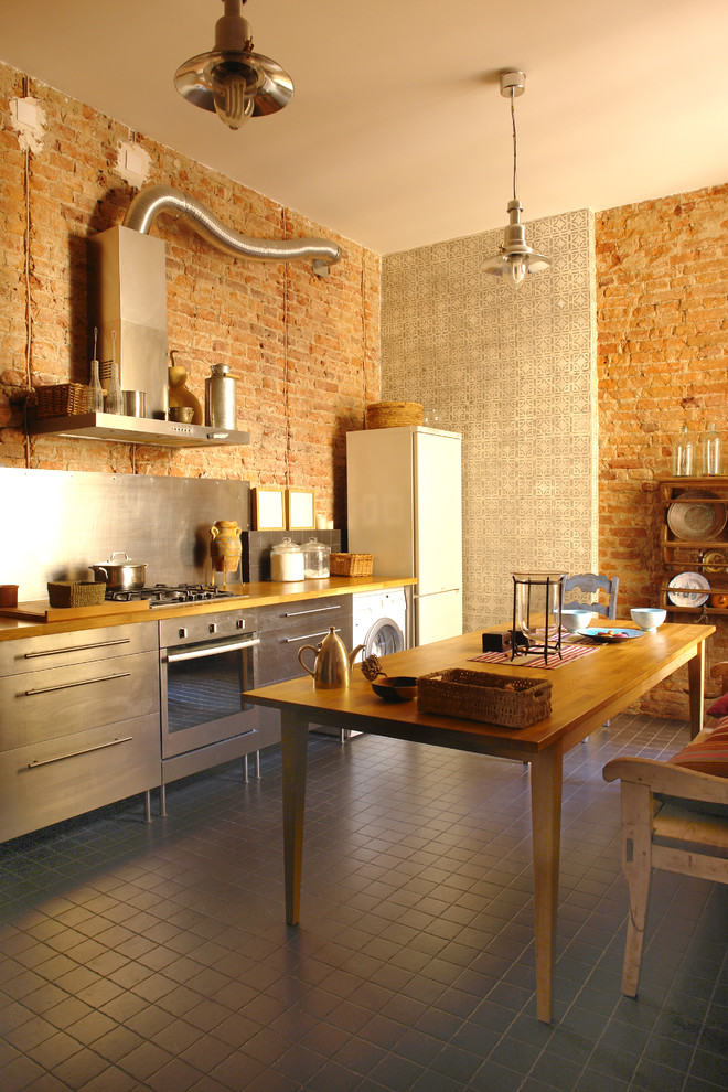 Inspiration for a large eat-in kitchen remodel in Minneapolis with stainless steel cabinets, wood countertops and stainless steel appliances