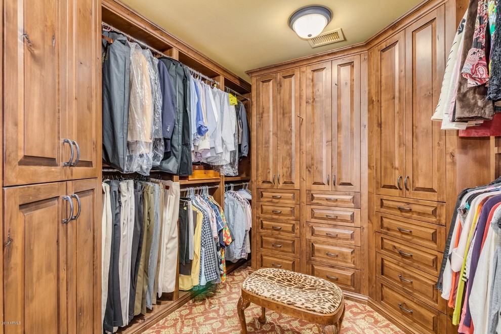 Photo of a large mediterranean gender-neutral walk-in wardrobe in Phoenix with carpet and multi-coloured floor.