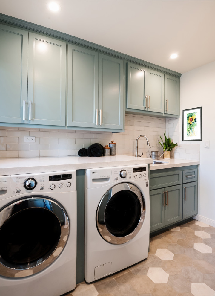 Inspiration for a mid-sized traditional galley dedicated laundry room in Los Angeles with a drop-in sink, beaded inset cabinets, turquoise cabinets, quartz benchtops, beige splashback, porcelain splashback, beige walls, porcelain floors, a side-by-side washer and dryer, beige floor and beige benchtop.