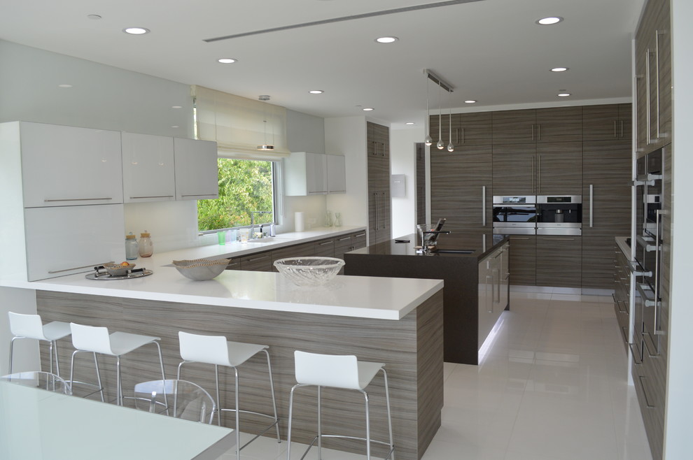Design ideas for a large modern eat-in kitchen in Los Angeles with an undermount sink, flat-panel cabinets, medium wood cabinets, solid surface benchtops, stainless steel appliances, marble floors and with island.