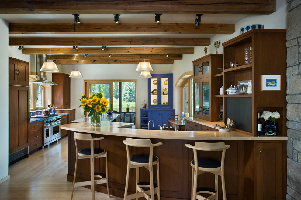 Design ideas for a country eat-in kitchen in Salt Lake City with shaker cabinets, dark wood cabinets and panelled appliances.