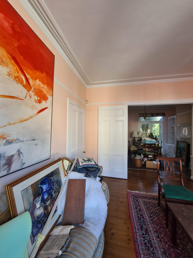 Exemple d'une grande salle à manger ouverte sur le salon chic avec un mur orange, parquet foncé, une cheminée standard, un manteau de cheminée en métal, un sol marron et un plafond décaissé.
