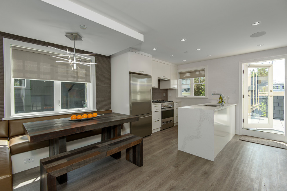 Example of a transitional galley vinyl floor and brown floor eat-in kitchen design in Vancouver with flat-panel cabinets, white cabinets, quartz countertops and white countertops