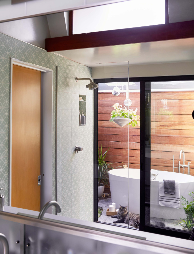 Photo of a midcentury master wet room bathroom in Orange County with flat-panel cabinets, grey cabinets, a freestanding tub, green tile, cement tile, pebble tile floors, a wall-mount sink, concrete benchtops, grey floor, an open shower and white benchtops.
