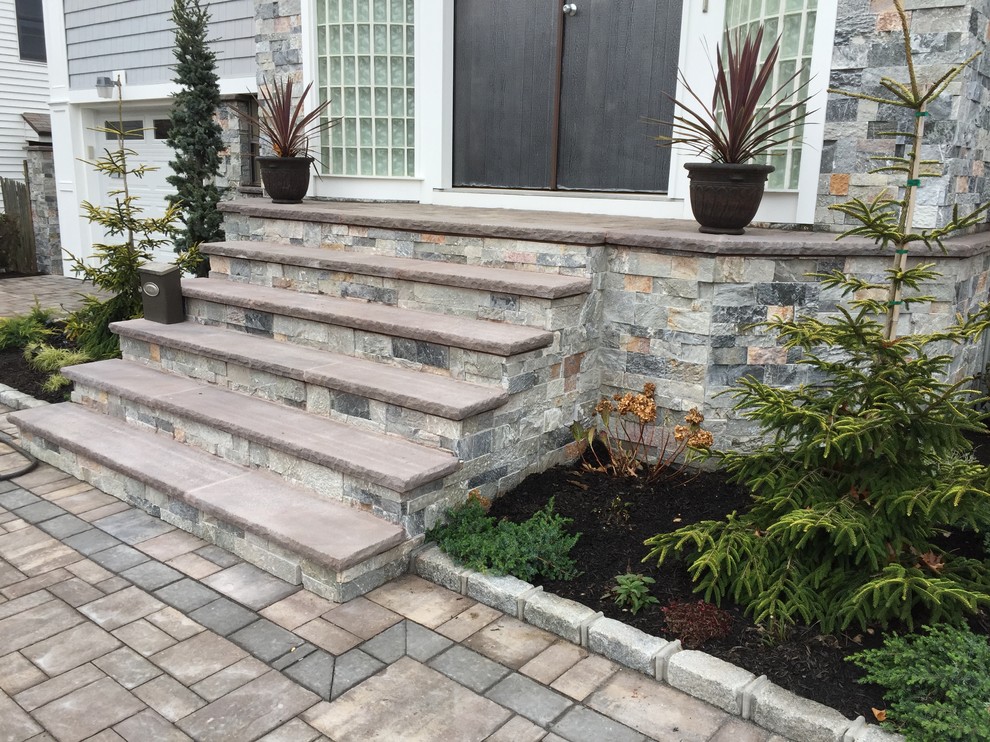 Photo of a mid-sized contemporary front yard verandah in New York with concrete pavers.