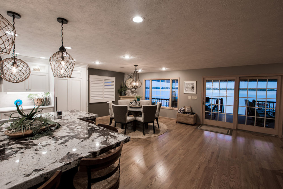 Eat-in kitchen - mid-sized transitional eat-in kitchen idea with shaker cabinets, white cabinets, quartz countertops, stainless steel appliances and an island