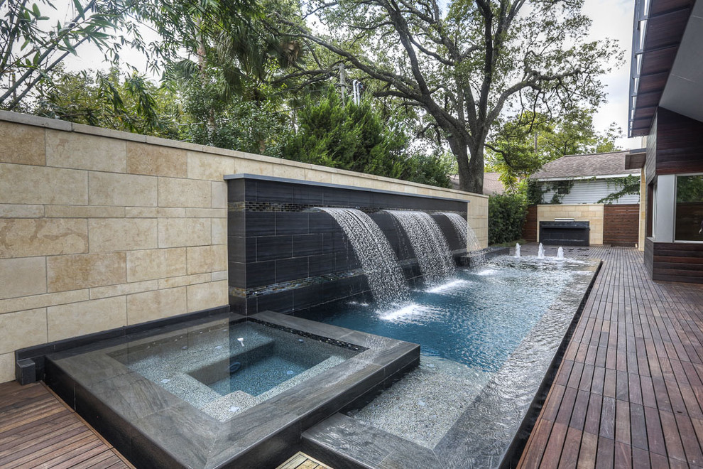 Inspiration for a small modern backyard patio in Houston with a water feature and decking.
