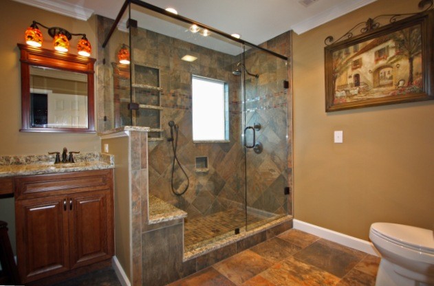 Photo of a large transitional master bathroom in Raleigh with an undermount sink, beaded inset cabinets, medium wood cabinets, granite benchtops, a corner tub, a double shower, a one-piece toilet, multi-coloured tile, porcelain tile, orange walls and porcelain floors.