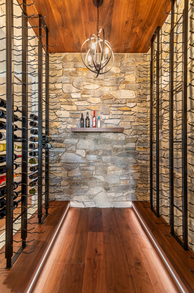 Inspiration for a mid-sized transitional wine cellar in Vancouver with medium hardwood floors, storage racks and brown floor.
