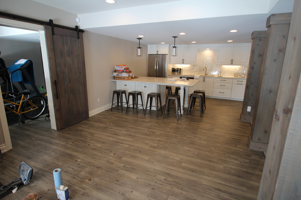 Inspiration for a mid-sized transitional single-wall vinyl floor eat-in kitchen remodel in Detroit with an undermount sink, raised-panel cabinets, white cabinets, quartz countertops, white backsplash, stone tile backsplash, stainless steel appliances and a peninsula