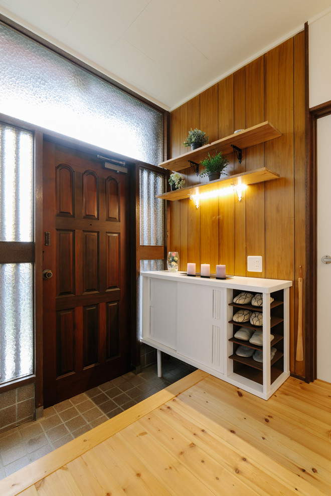 This is an example of a small asian entry hall in Other with brown walls, light hardwood floors, a single front door, a dark wood front door and beige floor.