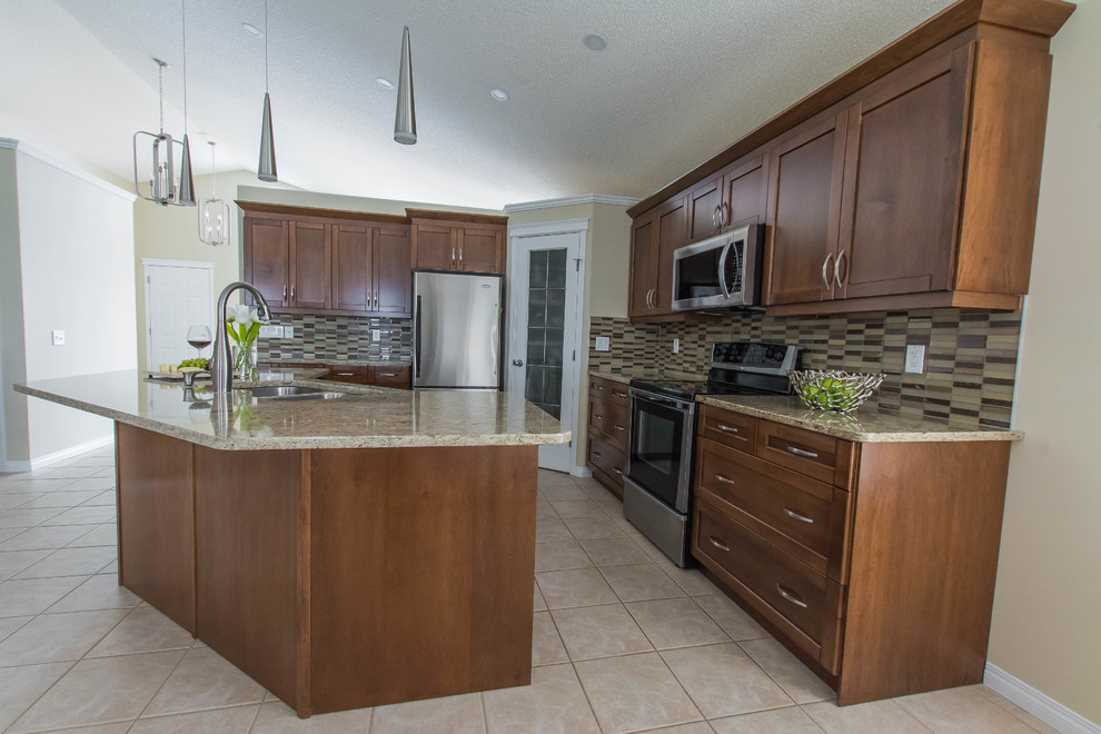 Eat-in kitchen - mid-sized transitional l-shaped ceramic tile and beige floor eat-in kitchen idea in Calgary with a double-bowl sink, shaker cabinets, brown cabinets, quartz countertops, beige backsplash, glass tile backsplash, stainless steel appliances and an island