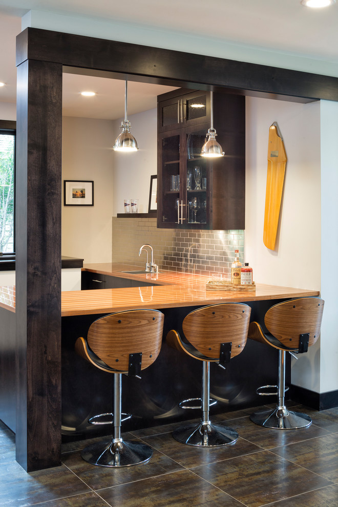 Inspiration for a country u-shaped wet bar in Minneapolis with a drop-in sink, dark wood cabinets, wood benchtops, metal splashback, brown floor and brown benchtop.