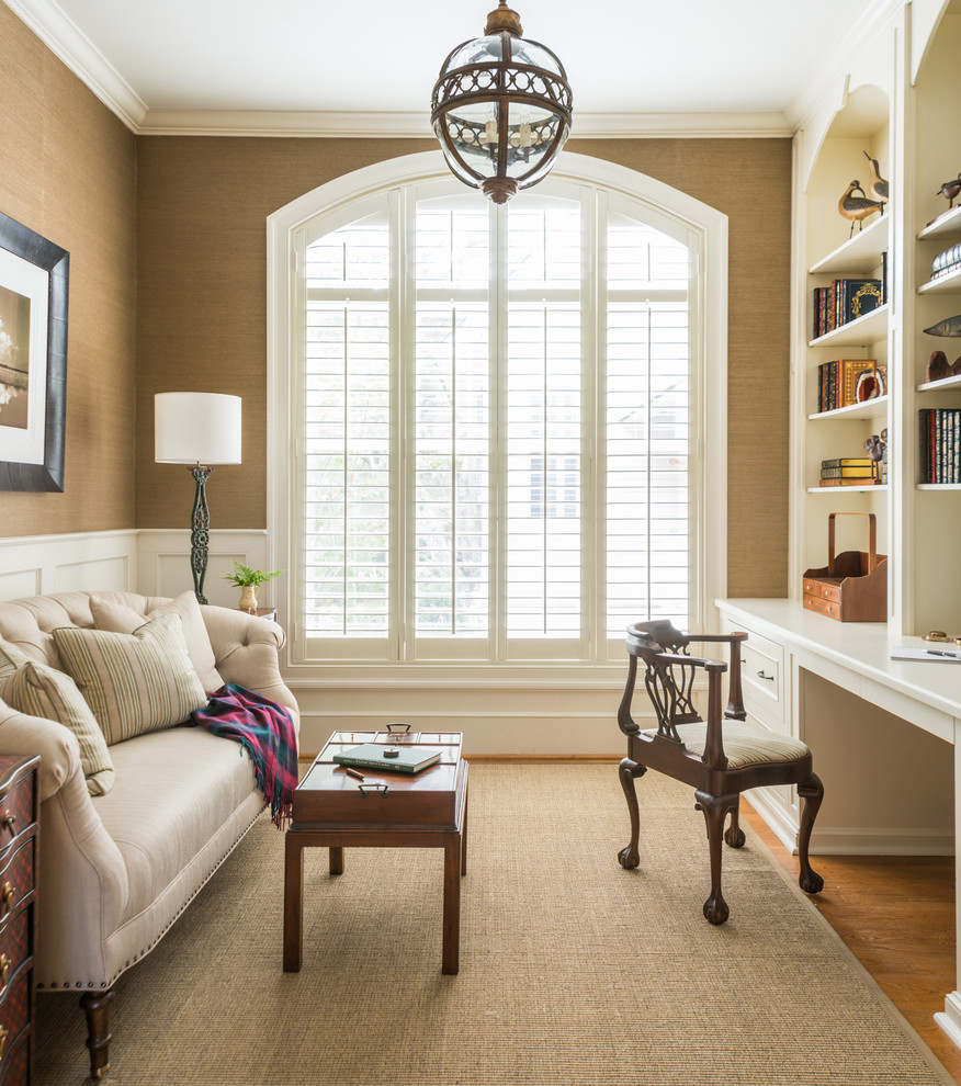 Traditional study room in Houston with brown walls, medium hardwood floors and a built-in desk.