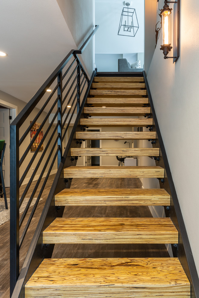 This is an example of a large contemporary wood straight staircase in Denver with open risers and metal railing.