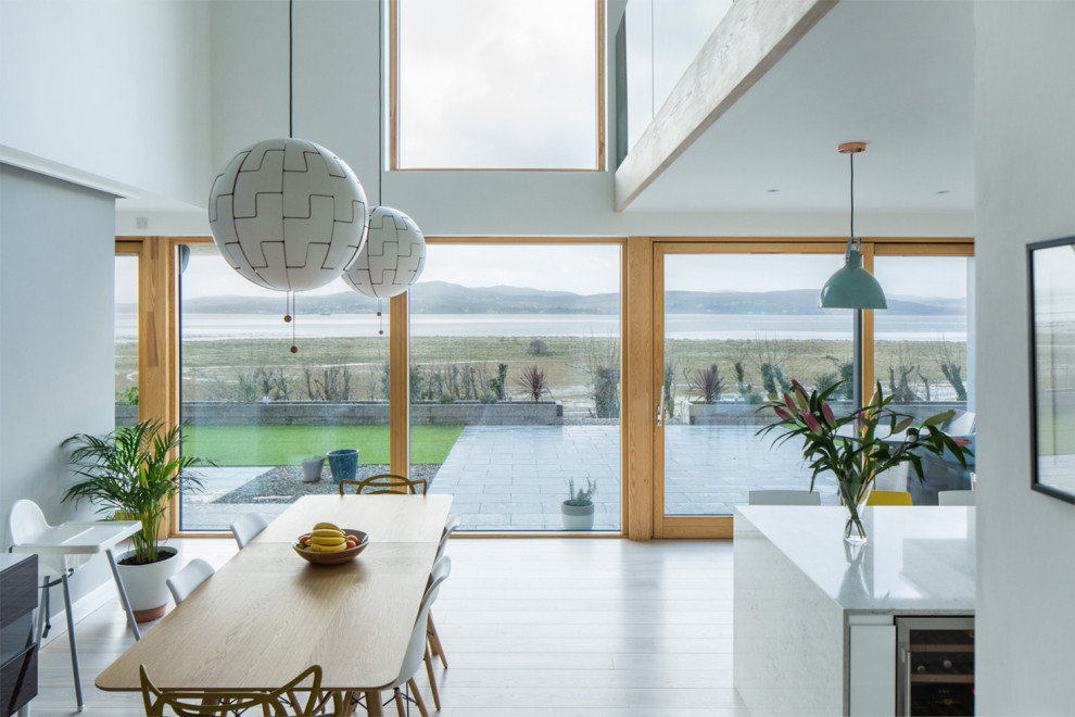 Immagine di una sala da pranzo aperta verso la cucina minimalista di medie dimensioni con pareti bianche