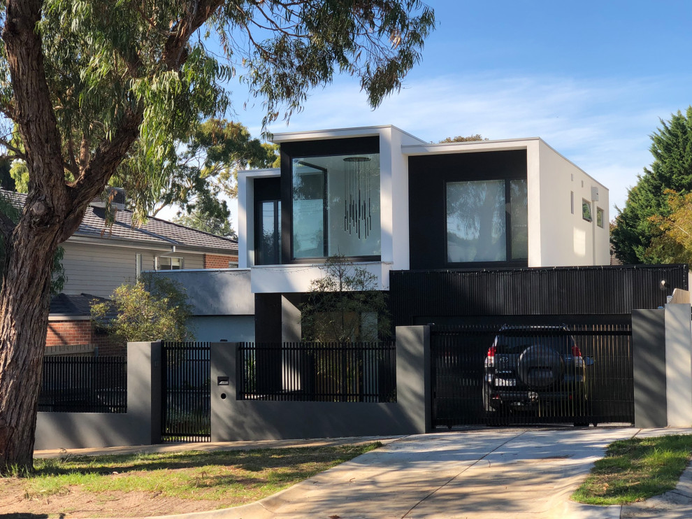 This is an example of a large contemporary two-storey white house exterior in Melbourne with mixed siding, a flat roof and a metal roof.