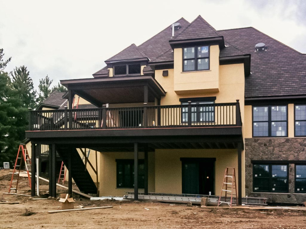 Photo of a two-storey stucco house exterior in Cleveland with a hip roof and a shingle roof.