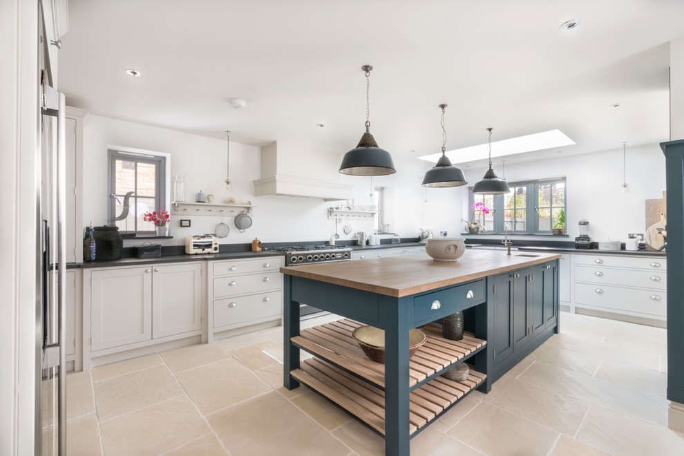 Design ideas for an expansive traditional u-shaped kitchen in Essex with a farmhouse sink, shaker cabinets, grey cabinets, granite benchtops, white splashback, terra-cotta floors, with island, beige floor, black benchtop and stainless steel appliances.