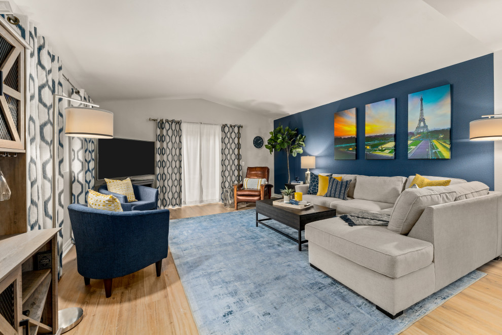 Design ideas for a mid-sized transitional open concept living room in Other with blue walls, vinyl floors and a freestanding tv.