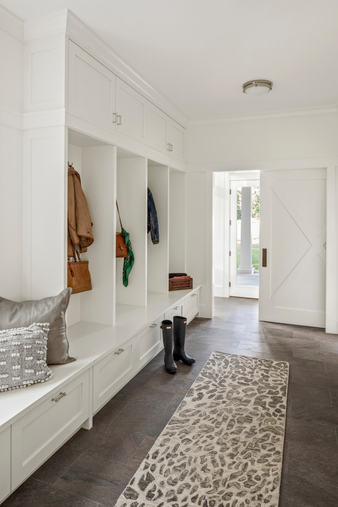Photo of a mid-sized country mudroom in Boston with white walls and slate floors.