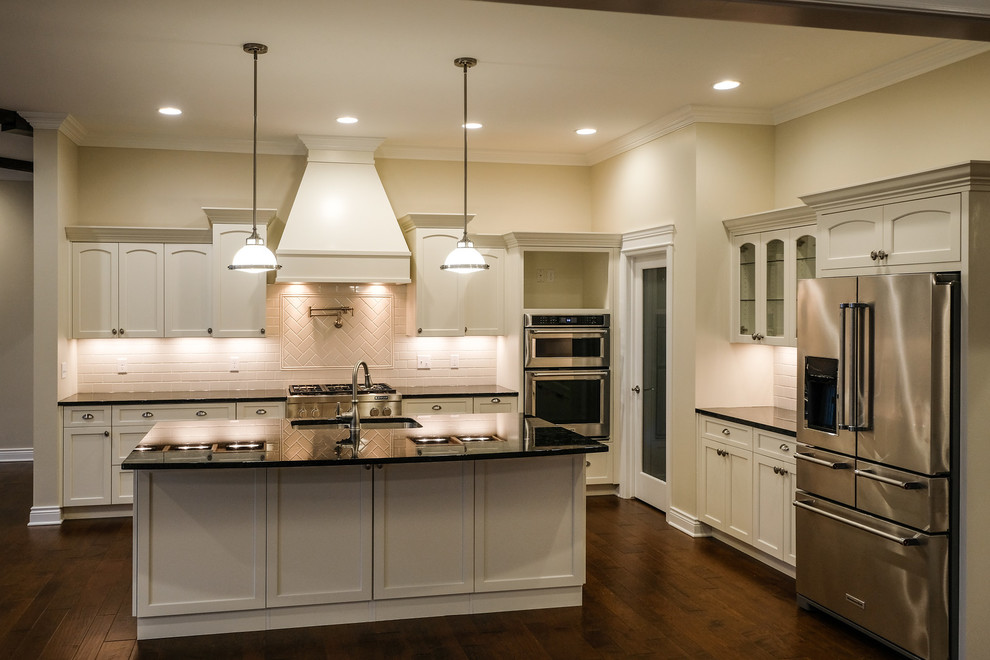 Eat-in kitchen - large transitional l-shaped dark wood floor and brown floor eat-in kitchen idea with an undermount sink, recessed-panel cabinets, white cabinets, granite countertops, white backsplash, stainless steel appliances, an island and blue countertops