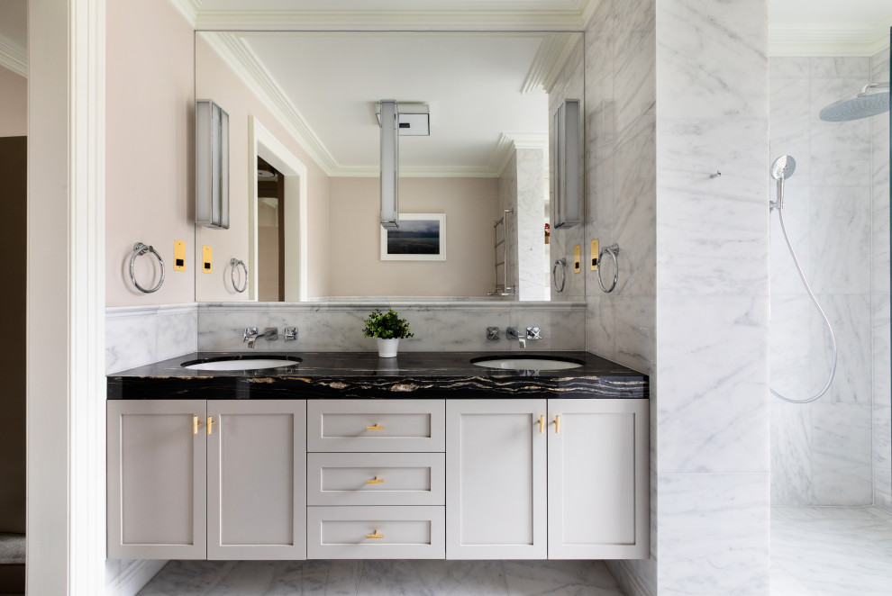 Example of a transitional gray tile gray floor and double-sink bathroom design in Other with shaker cabinets, gray cabinets, beige walls, an undermount sink, black countertops and a floating vanity